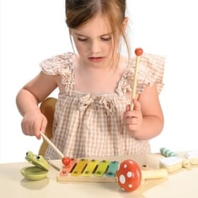 Young Girl Playing with a Woodland Music Set